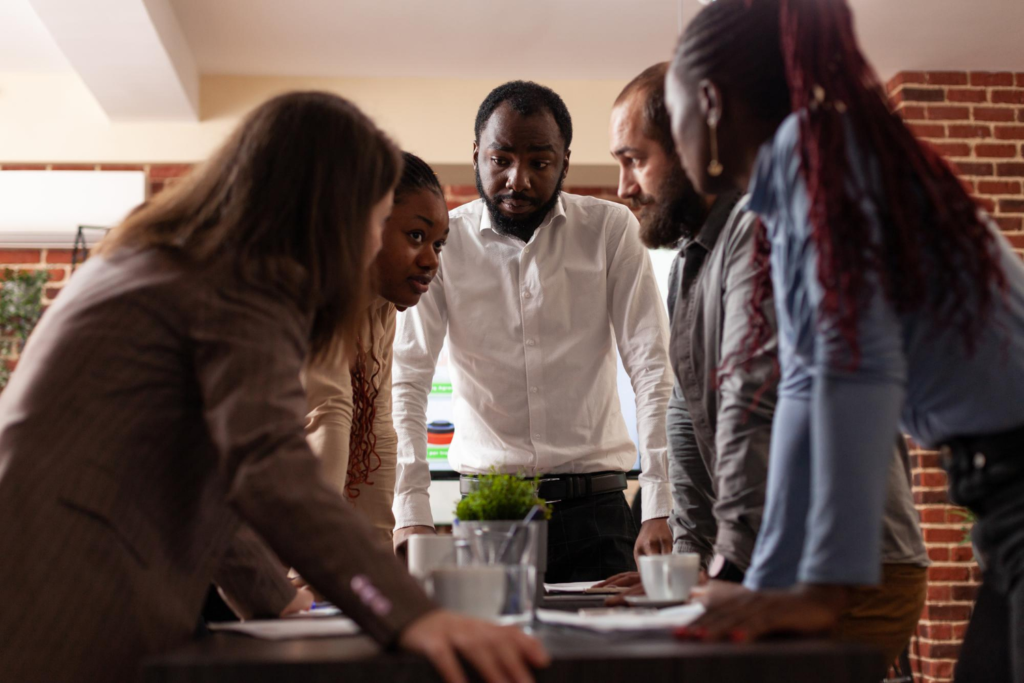 Multi Ethnic Entrepreneurs Stand Up Analyzing Financial Graph Brainstorming Ideas Partnership Project Working Company Presentation Startup Office Executives Managers Having Business Meeting 1